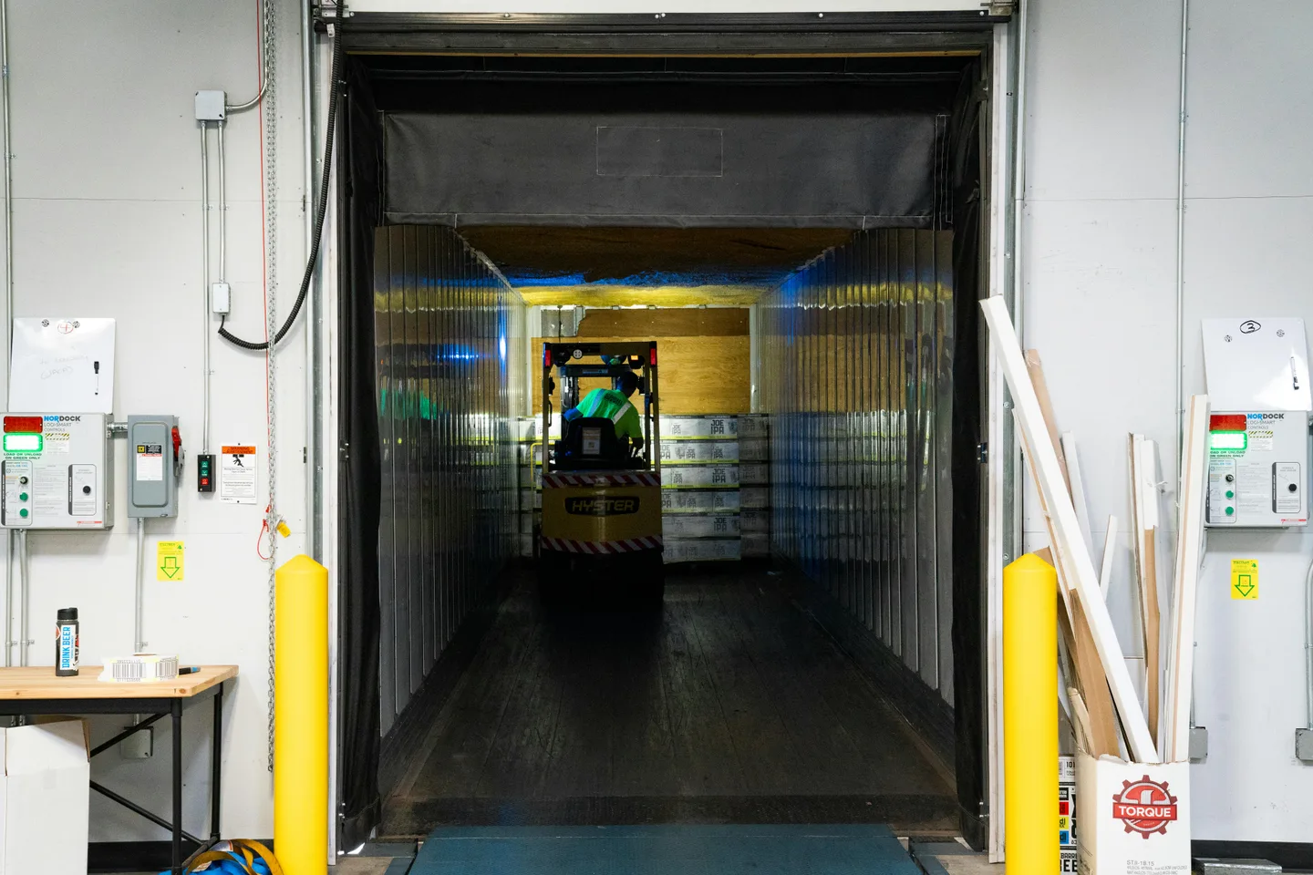 A worker operates a forklift in a cold storage facility