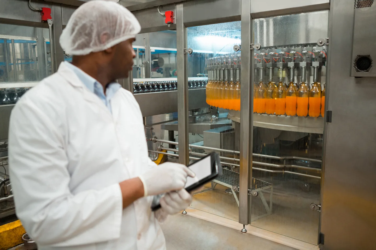 A worker inspects juice at a bottling plant
